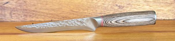 Rugged stainless steel boning knife with hammer-forged blade and Pakka wood handle.