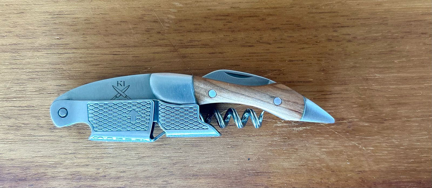 Rosewood Wine Corkscrew with stainless steel tip on wooden surface.