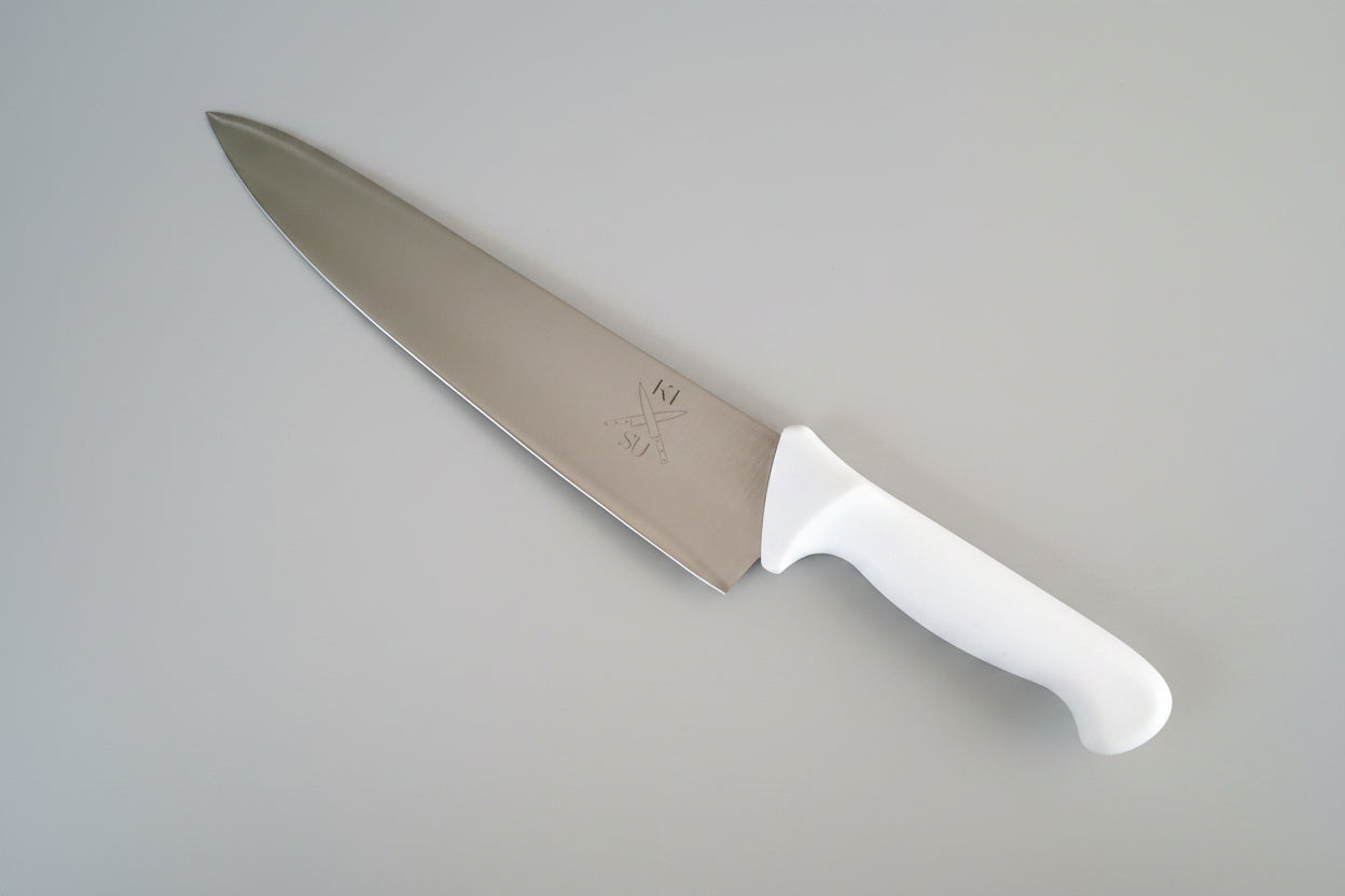 Chef's knife with a white handle on a gray marble surface