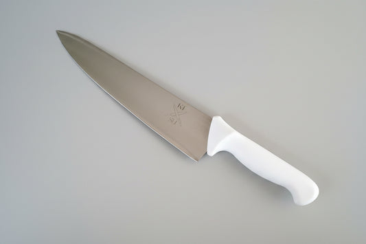 Chef's knife with a white handle on a gray marble surface