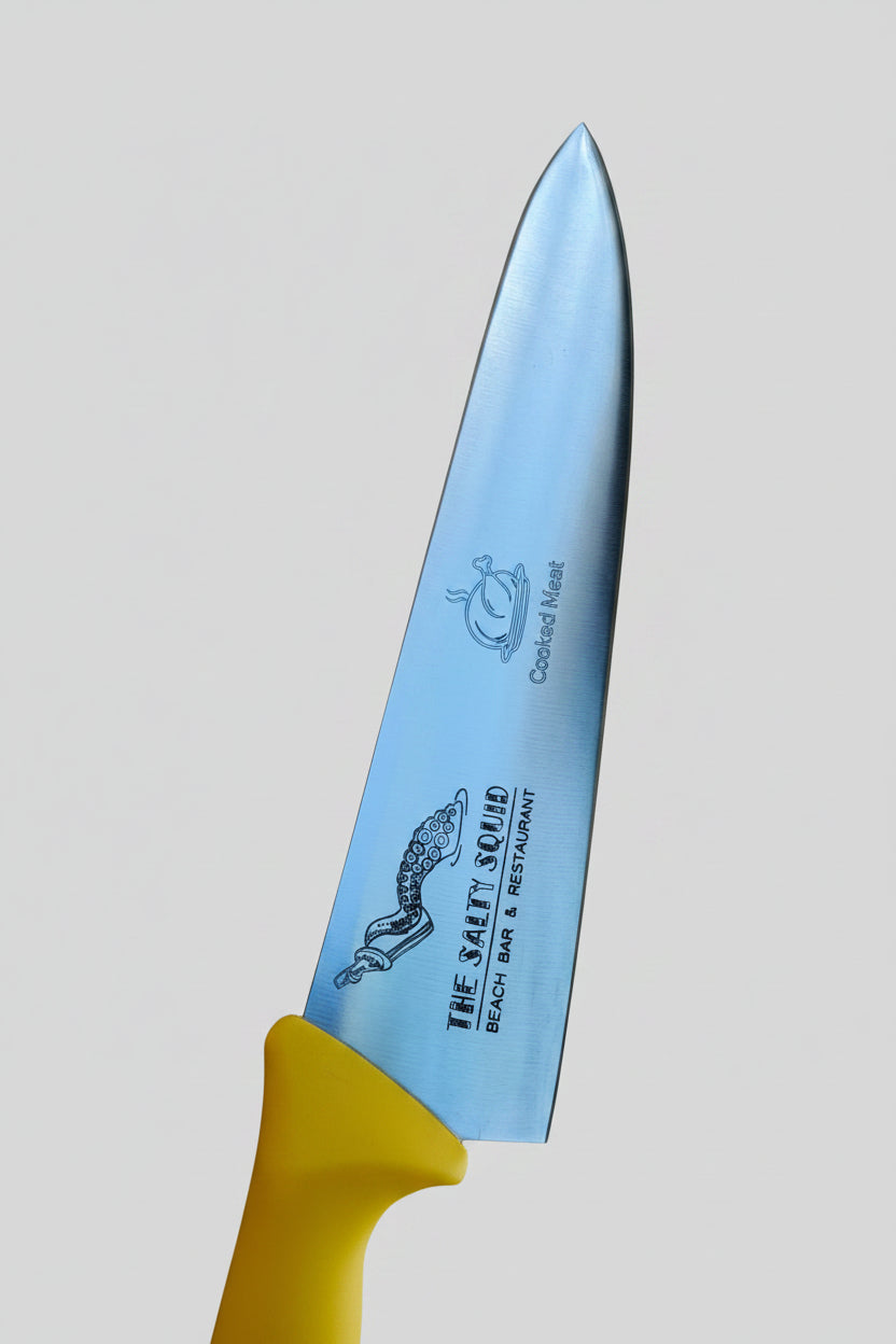 Knife with a yellow handle on a textured stone surface