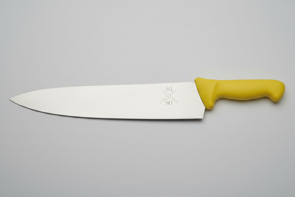 Large knife with a yellow handle on a wooden surface