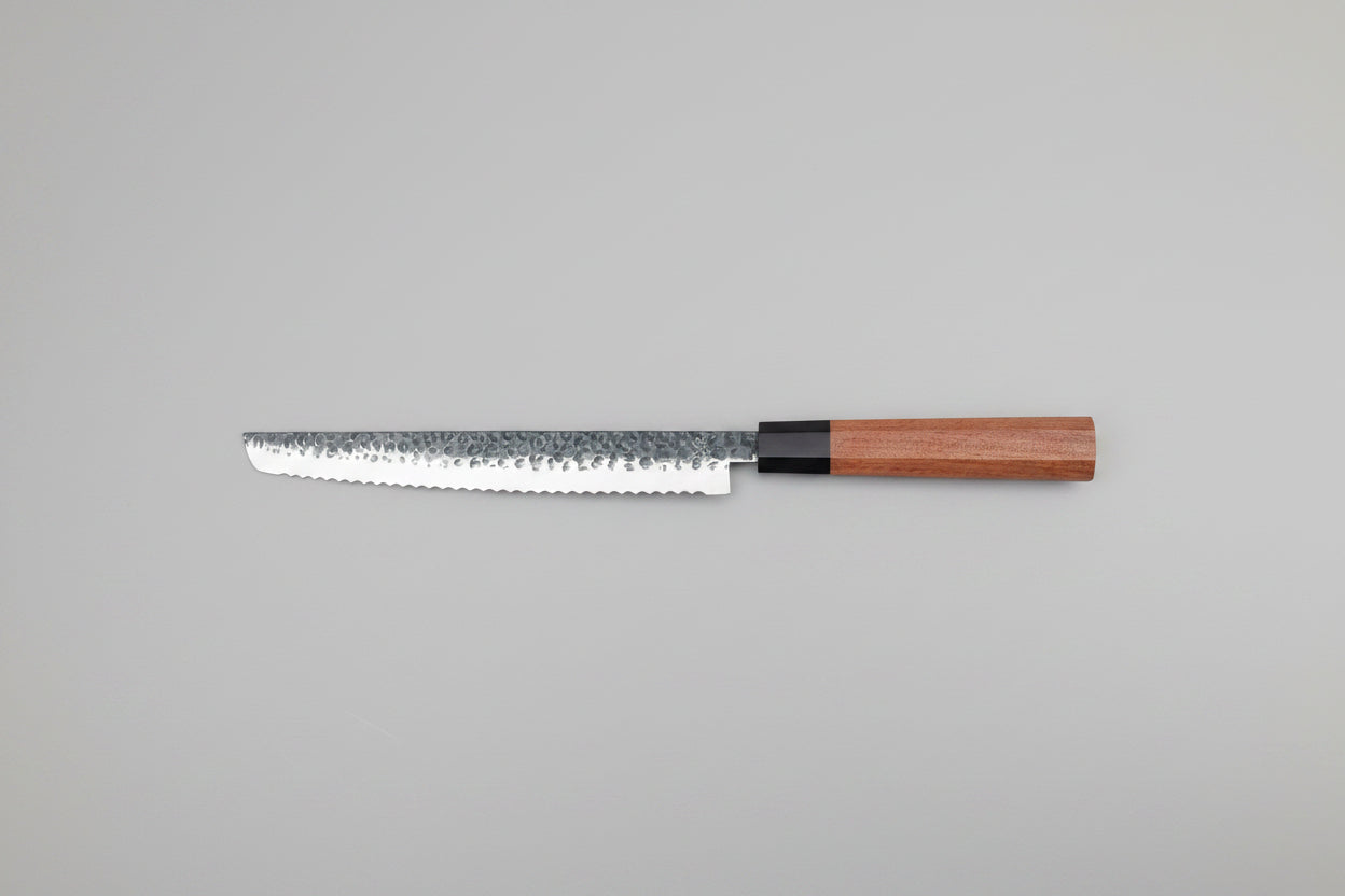 Wooden bread knife with a metal blade on a wooden surface