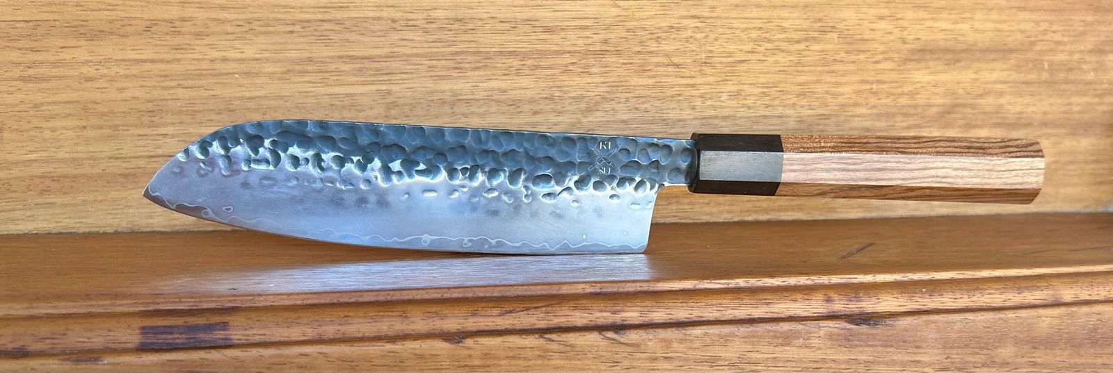Premium Tokai Range Santuko 7" Japanese Chef Knife with Damascus steel blade and ergonomic wooden handle.
